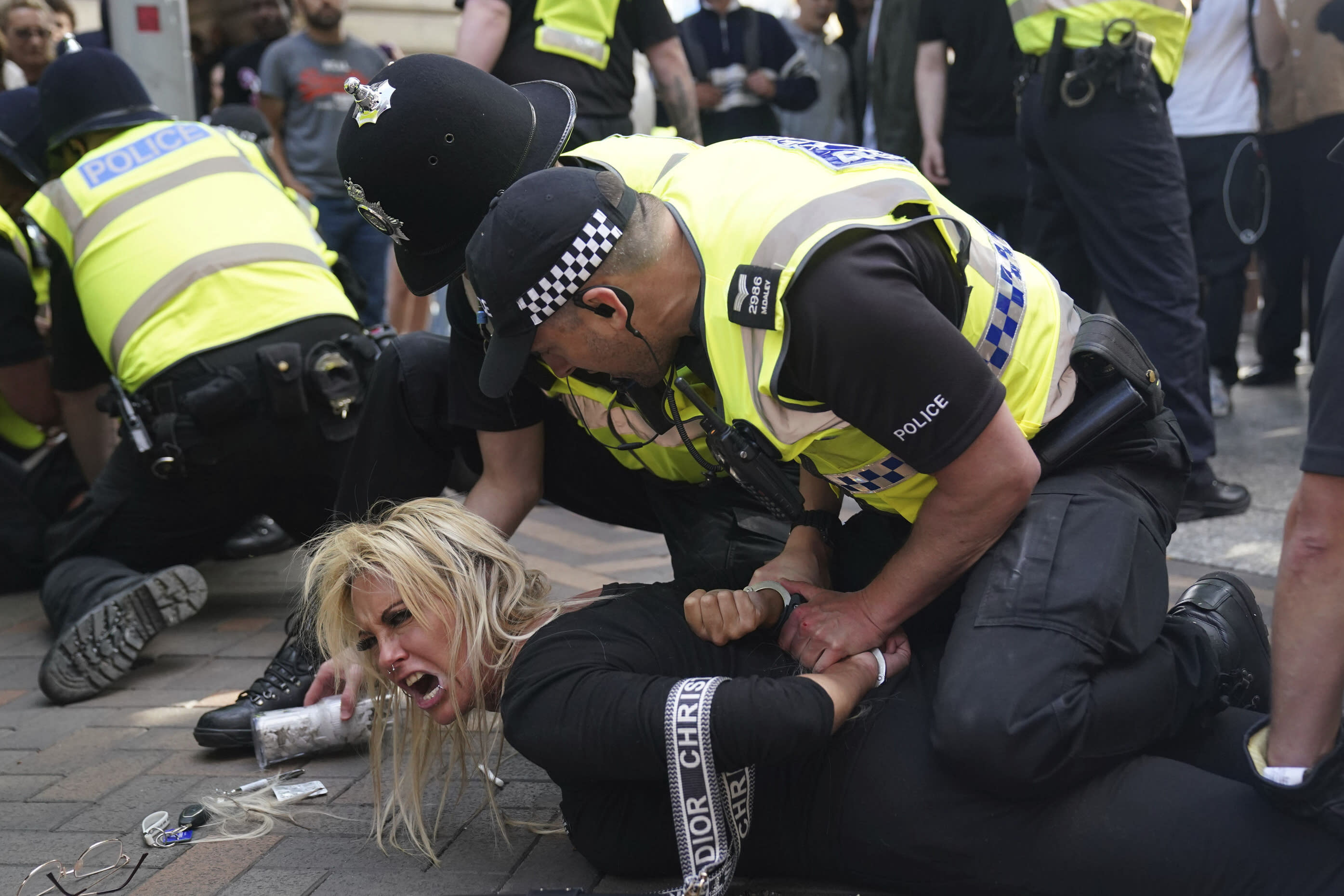 Police officers detain a woman during a protest in Nottingham, England