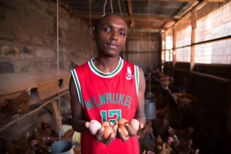 Victor Kyalo holds half a dozen eggs at his small household farm in the outskirts of Nairobi