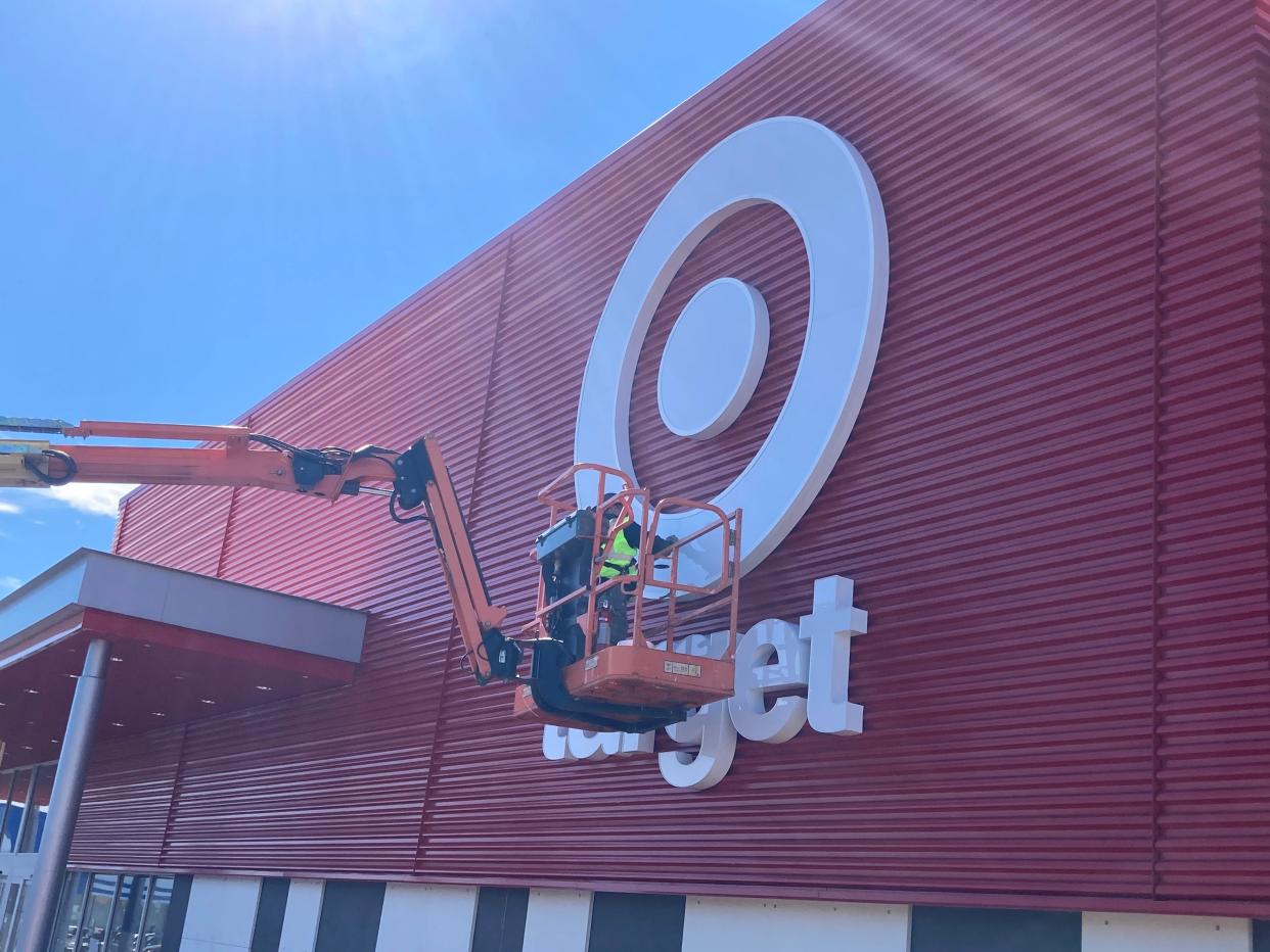 Construction crews attach the Target bullseye logo to the company's Prices Corner store on Wednesday, Feb. 24, 2021.