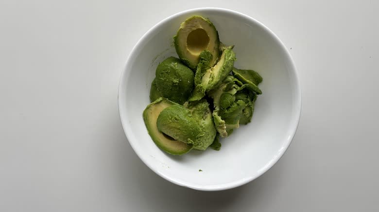 peeled avocados in white bowl