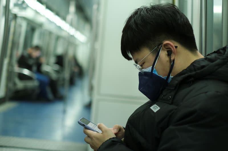 A man wearing two face masks travels in the subway, as the country is hit by an outbreak of the new coronavirus, in Beijing