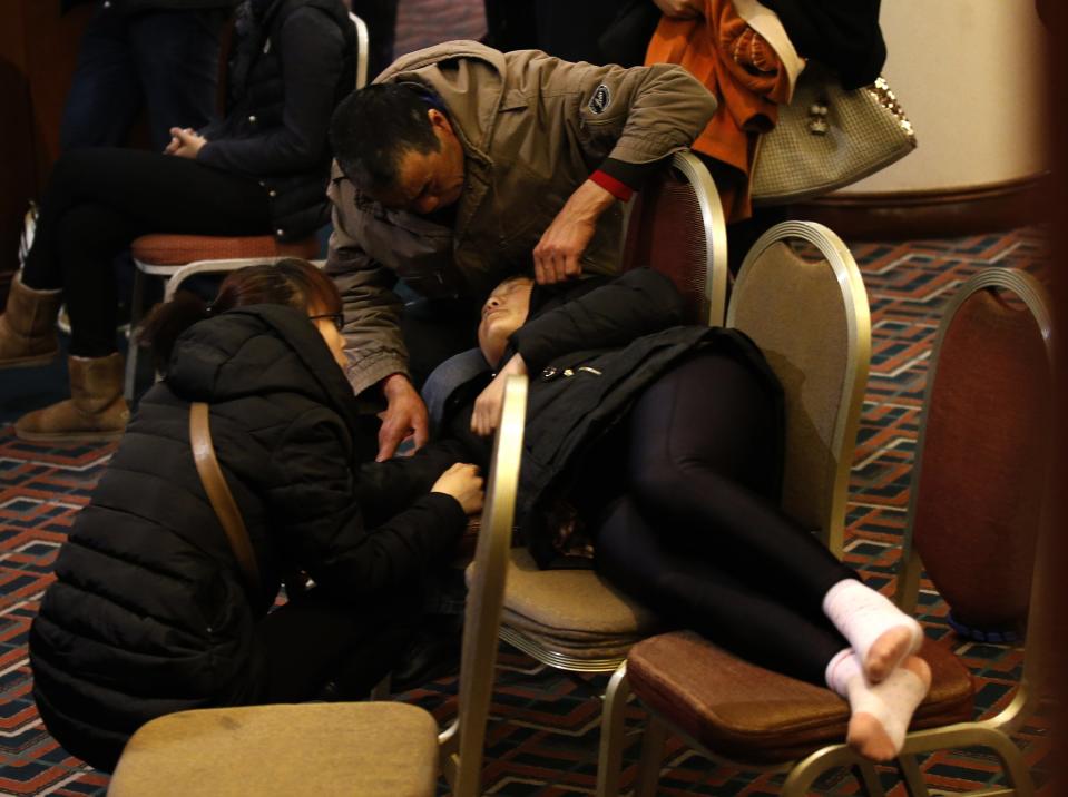 A family member of a passenger aboard the missing Malaysia Airlines Flight MH370 rests on chairs as relatives continue to wait for news at a hotel in Beijing
