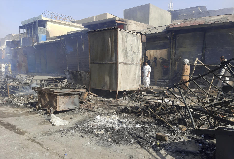 Afghans inspect damaged shops after fighting between Taliban and Afghan security forces in Kunduz city, northern Afghanistan, Sunday, Aug. 8, 2021. Taliban fighters Sunday took control of much of the capital of Kunduz province, including the governor's office and police headquarters, a provincial council member said. (AP Photo/Abdullah Sahil)