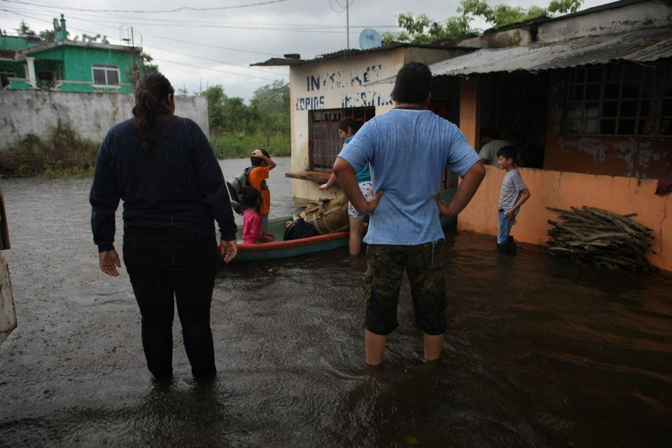 Habitantes de Ixtacomitan abandonan sus hogares debido a las inundaciones por las intensas lluvias.