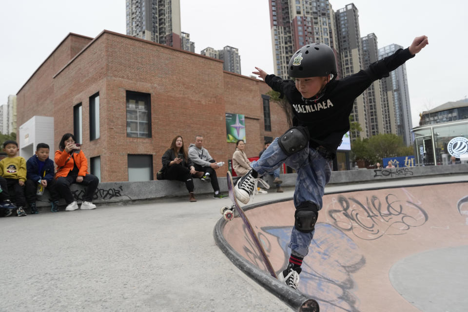 A young boy skates at a trendy district popular with youths in Chengdu, the capital of the southwestern China's Sichuan province, Sunday, March 17, 2024. Sichuan has come to dominate in the industry as rap has gone mainstream, with the region's dialect lending itself to rhymes and some of the biggest acts coming from the region. (AP Photo/Ng Han Guan)
