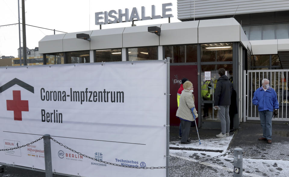 People wait at the entrance of a new open coronavirus, COVID-19, vaccination center in the 'Erika-Hess-Ice-Stadium' in Berlin, Germany, Thursday, Jan. 14, 2021. (AP Photo/Michael Sohn)