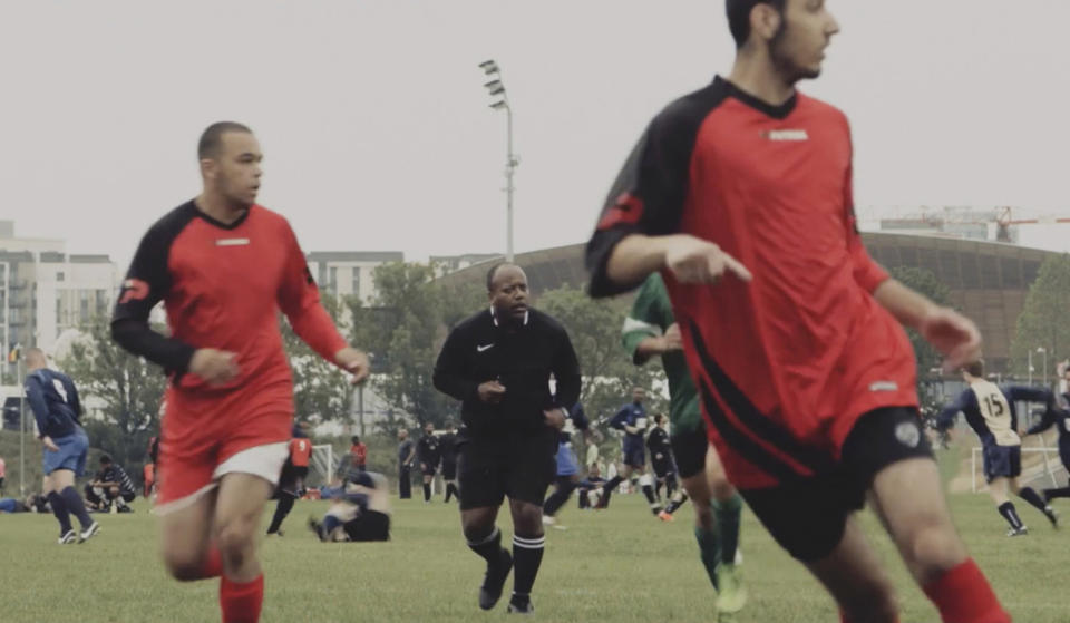 This grab taken from video taken on Aug. 23, 2015, shows Jermaine Wright, centre, a NHS pharmacist and a referee of the Hackney Marshes grassroots football league overseeing a match. Wright, affectionately known as Mr. Hackney Marshes, served as both an on-field referee and a behind-the-scenes catalyst in the Hackney & Leyton Sunday Football League — as vice chairman, schedule secretary, results secretary, press officer, and head official before he died on April 27, 2020 from COVID-19. (Thomas Wootton via AP)