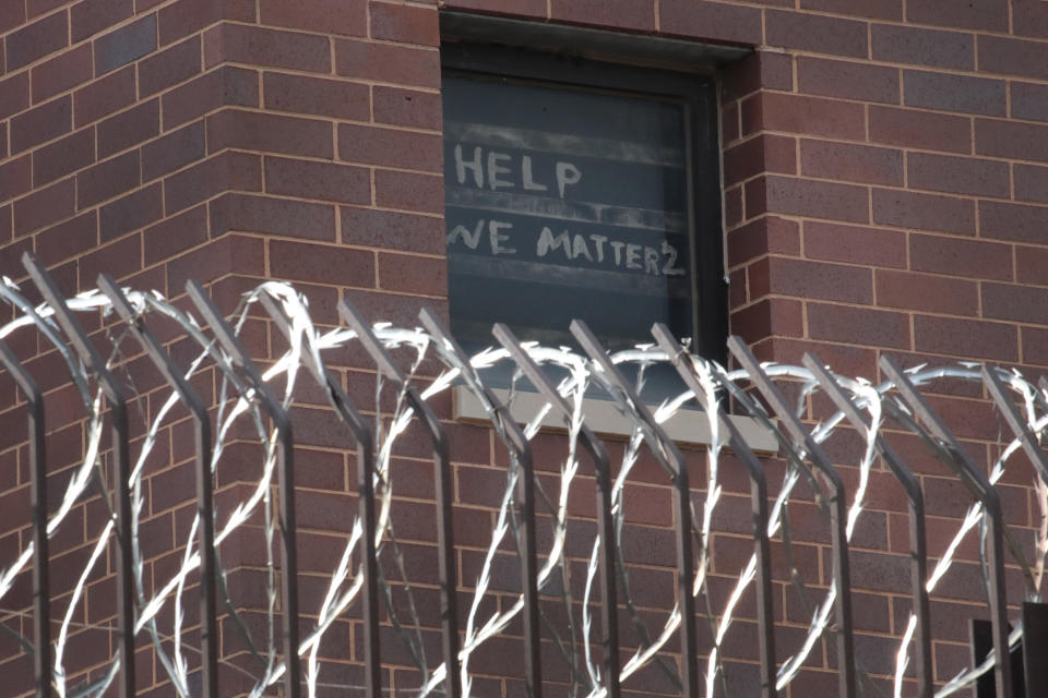 A sign pleading for help hangs in a window at the Cook County jail complex 