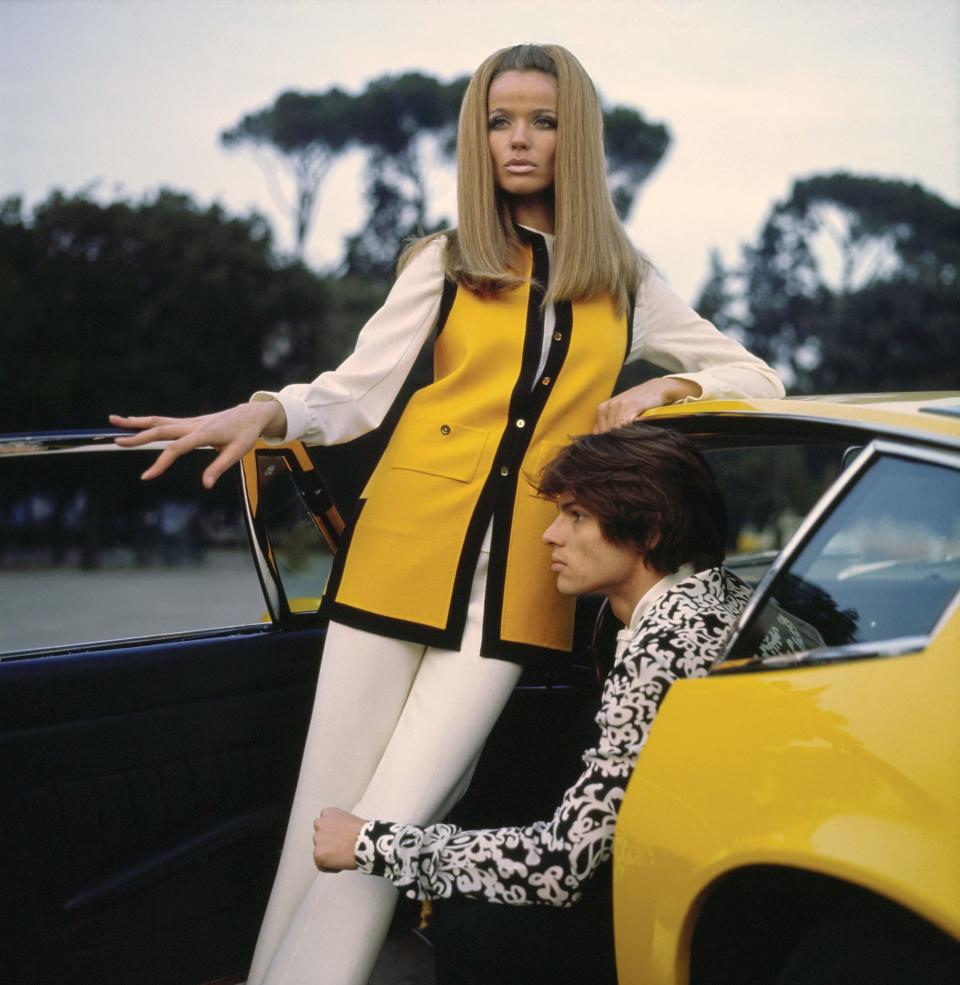 Veruschka in Mila Schön’s “double-face wool pantsuit with a tucked ecru shirt under a sleeveless, black-bound, Maserati-yellow jacket.”