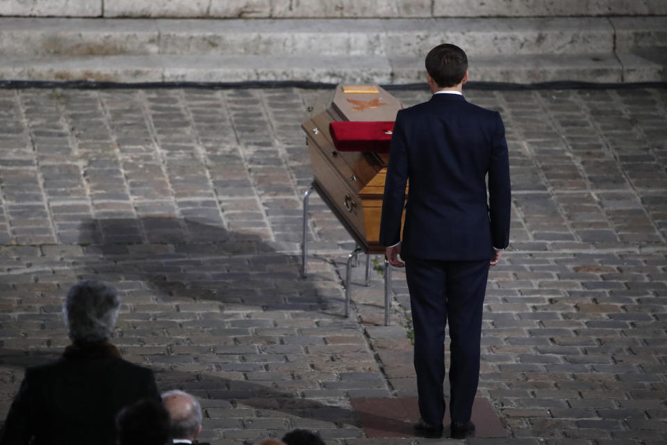French President Emmanuel Macron pays his respects by the coffin of slain teacher Samuel Paty in the courtyard of the Sorbonne university during a national memorial event, Wednesday, Oct. 21, 2020 in Paris. French history teacher Samuel Paty was beheaded in Conflans-Sainte-Honorine, northwest of Paris, by a 18-year-old Moscow-born Chechen refugee, who was later shot dead by police. (AP Photo/Francois Mori, Pool)