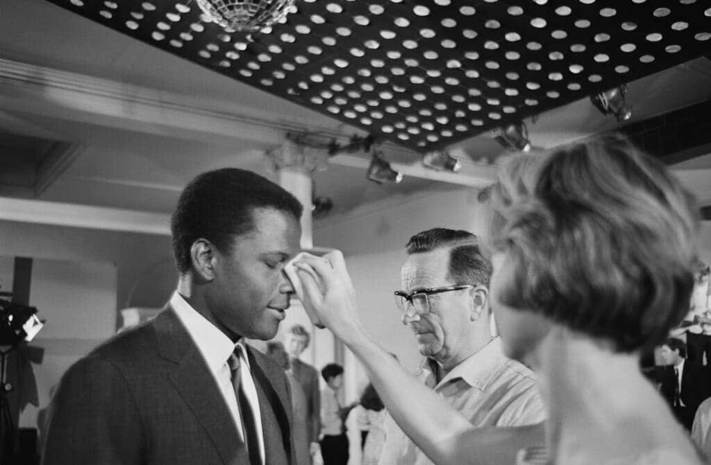 Bahamian American actor Sidney Poitier has his make-up adjusted on the set of ‘To Sir, With Love’, directed by James Clavell, 16th June 1966. The crew are filming a party scene at Victoria Barracks, Windsor Castle. (Photo by Chris Ware/Keystone Features/Hulton Archive/Getty Images)