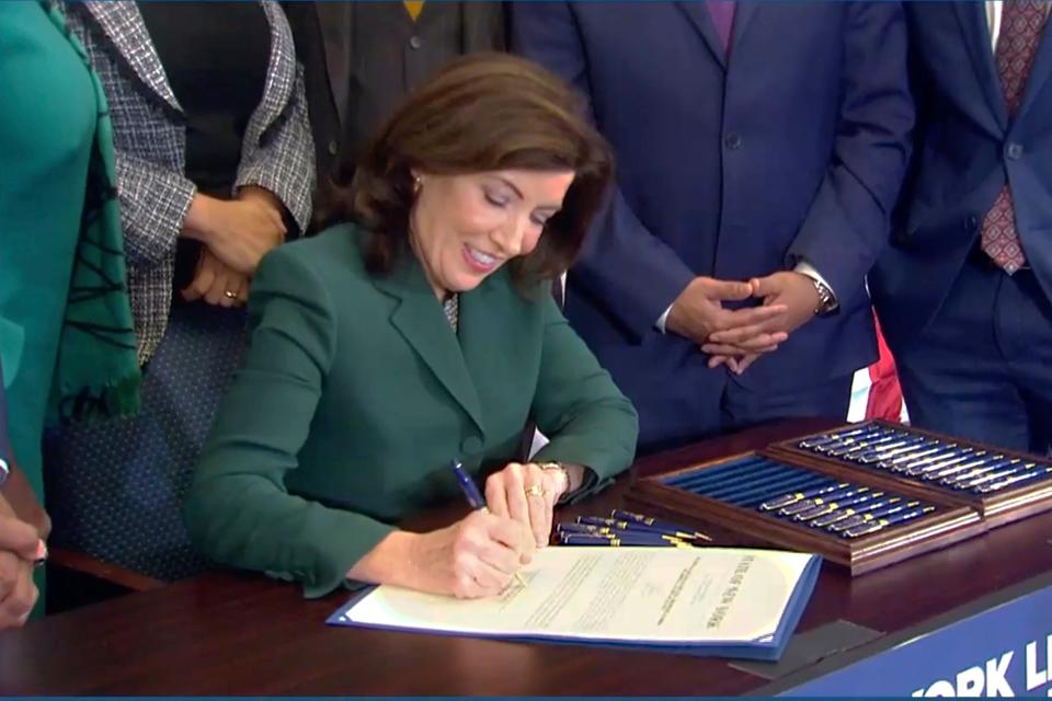 This image from video provided by the Office of The Governor shows New York Gov. Kathy Hochul as she signs a bill in Albany, NY, Tuesday, Dec. 19, 2023, to create a commission tasked with considering reparations to address the persistent, harmful effects of slavery in the state. (Office of the Governor via AP)