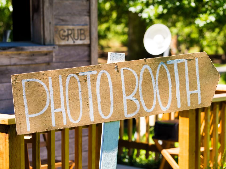 Wood sign at wedding outside that reads "photo booth"