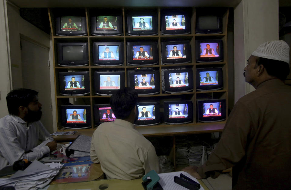 People watch a televised address of Pakistan's newly elected Prime Minister Imran Khan at an office in Karachi, Pakistan, Sunday, Aug. 19, 2018. Pakistan's newly elected prime minister Imran Khan Sunday said the country was in its worst economic condition and pledged to improve it by adopting austerity to cut government expenditure, introducing progressive taxation, end corruption and bringing back from abroad the plundered public money. (AP Photo/Fareed Khan)