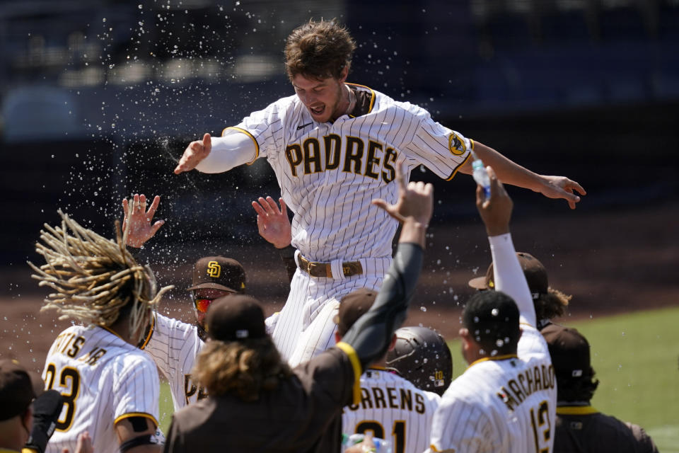 FILE - In this Aug. 27, 2020 file photo, San Diego Padres' Wil Myers, top, reacts after hitting a three-run walkoff home run to defeat the Seattle Mariners in a baseball game in San Diego. Wil Myers is back. While Manny Machado and Fernando Tatis Jr. have grabbed most of the attention on the playoff-bound Padres, Myers' comeback performance has also been instrumental in returning San Diego to postseason play for the first time since 2006. Myers is hitting .291 with 14 homers and 38 RBIs in 52 games. (AP Photo/Gregory Bull, File)