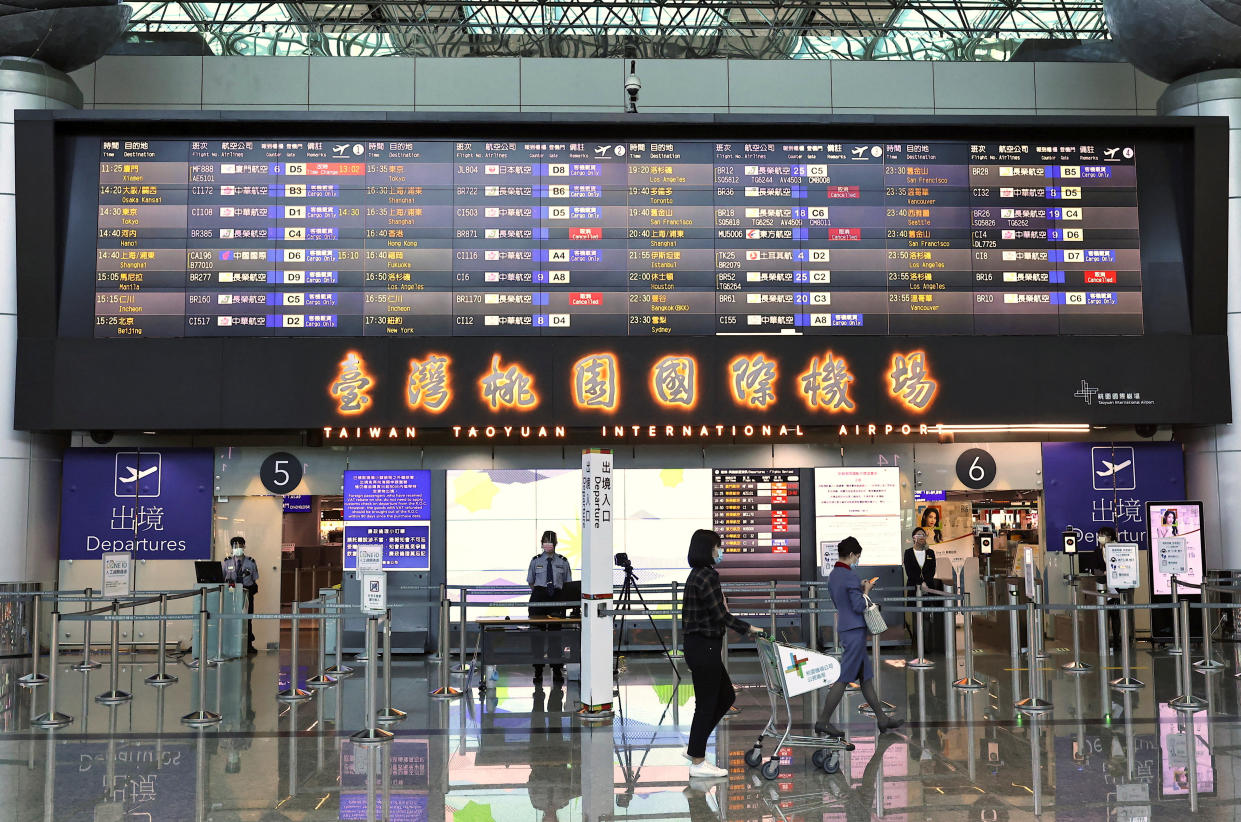 People walk past the departure gate at Taoyuan International Airport in Taoyuan, Taiwan, August 4, 2022. REUTERS/Ann Wang