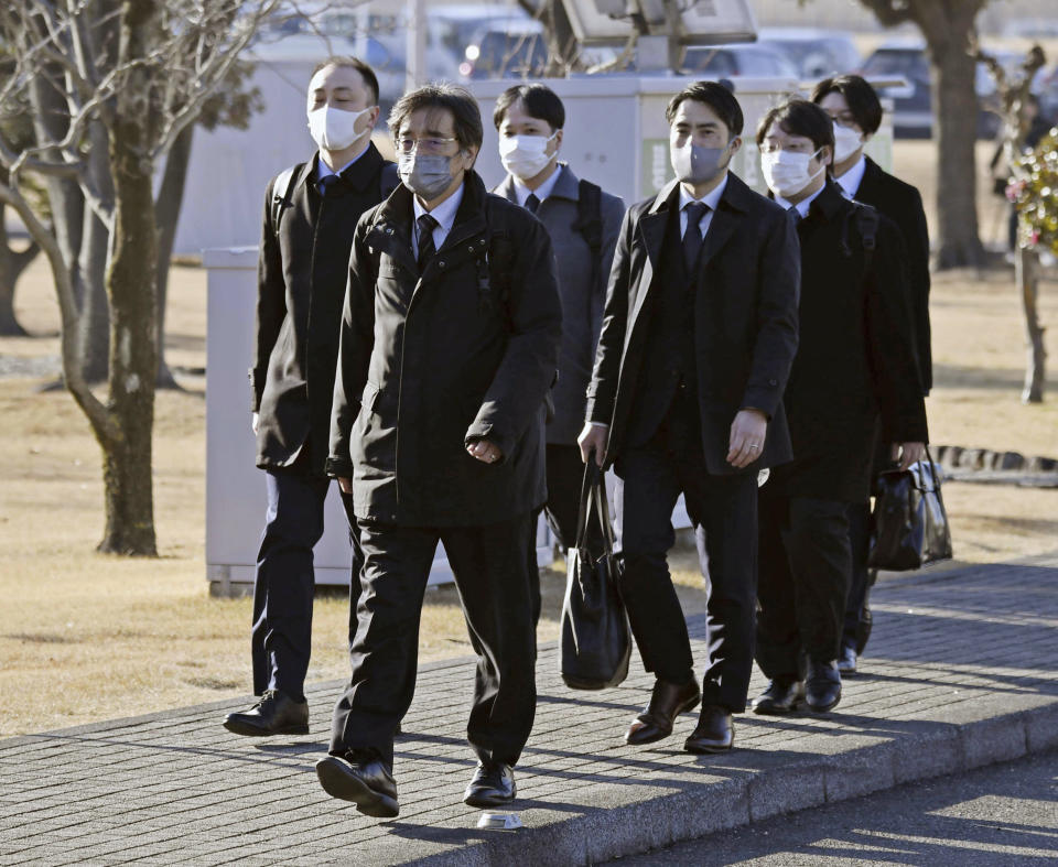 Japanese transport officials walk towards a Toyota Industries Corp. factory for inspections in Hekinan, central Japan, Tuesday, Jan. 30, 2024. Japanese transport officials raided the factory of the Toyota group company on Tuesday to investigate cheating on engine testing as its chairman vowed to ensure it is "making good cars." (Kyodo News via AP)