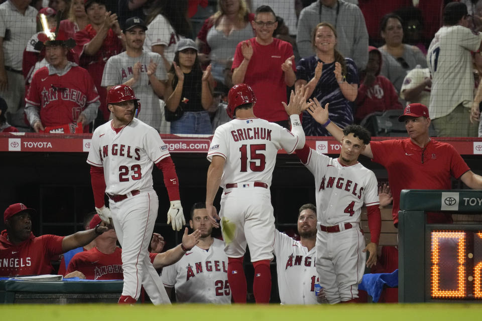 Los Angeles Angels' Randal Grichuk (15) returns to the dugout after scoring off of a single hit by Luis Rengifo during the seventh inning of a baseball game against the San Francisco Giants in Anaheim, Calif., Monday, Aug. 7, 2023. (AP Photo/Ashley Landis)