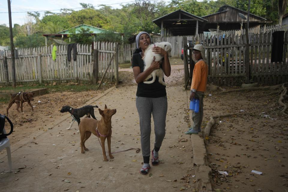 La venezolana Johany "Flaca" Rodríguez carga con su perro Kiko en brazos en un refugio para migrantes en Assis, Brasil, el 20 de junio de 2024. Rodríguez ha estado alargando su estancia en el albergue porque le han contado lo complicado que es ahora llegar a Estados Unidos. (AP Foto/Martín Mejía)