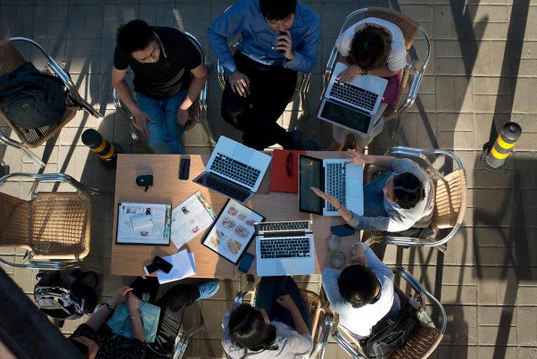 People sit around laptop computers at a cafe in Beijing on May 29, 2013