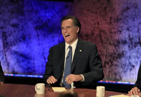 Former Massachusetts Governor Mitt Romney laughs as he gathers with other Republican presidential hopefuls for a debate at Dartmouth College in Hanover, New Hampshire, October 11, 2011. REUTERS/Adam Hunger