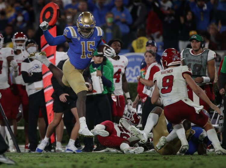 PASADENA, CA - SEPTEMBER 18, 2021: UCLA Bruins linebacker Jordan Genmark Heath (15) leaps over Fresno State defense after recovering a fumble in the 4th quarter at the Rose Bowl on September 18, 2021 in Pasadena, California.(Gina Ferazzi / Los Angeles Times)