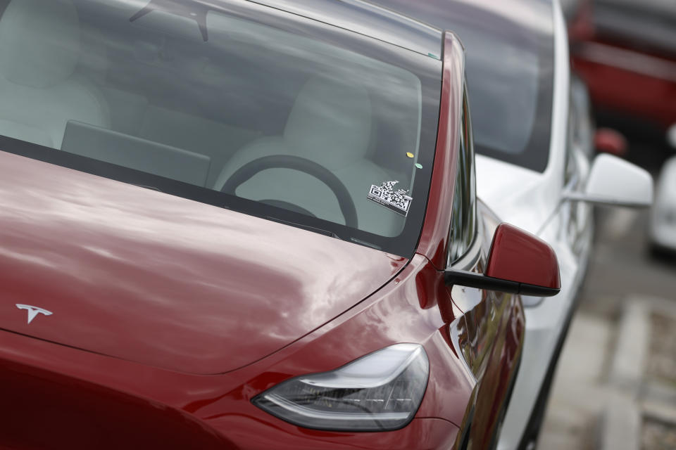 In this Sunday, June 28, 2020, photograph, a long line of unsold 2020 Model Y sports-utility vehicles sits at a Tesla dealership in Littleton, Colo. (AP Photo/David Zalubowski)