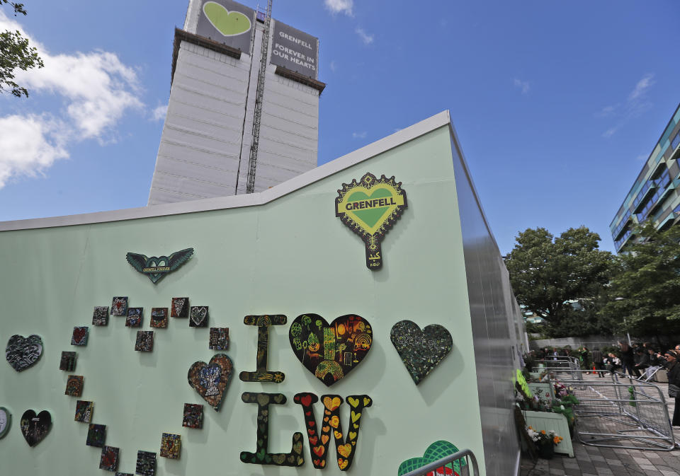 People mourn at the Grenfell tower to mark the two-year anniversary of the Grenfell Tower block fire in London, Friday, June 14, 2019. Survivors, neighbors and politicians including London Mayor Sadiq Khan attended a church service of remembrance on Friday for the Grenfell Tower blaze, the deadliest fire on British soil since World War II. (AP Photo/Frank Augstein)