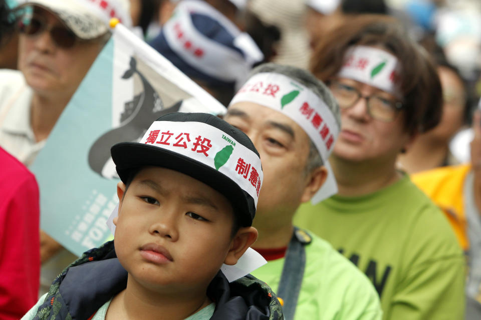 Protesters wearing headbands reading "Independence referendum" attend a rally in Taipei, Taiwan, Saturday, Oct. 20, 2018. Thousands of pro-independence demonstrators gathered in Taiwan’s capital on Saturday to express their disapproval with China’s stance toward their island. (AP Photo/Chiang Ying-ying)