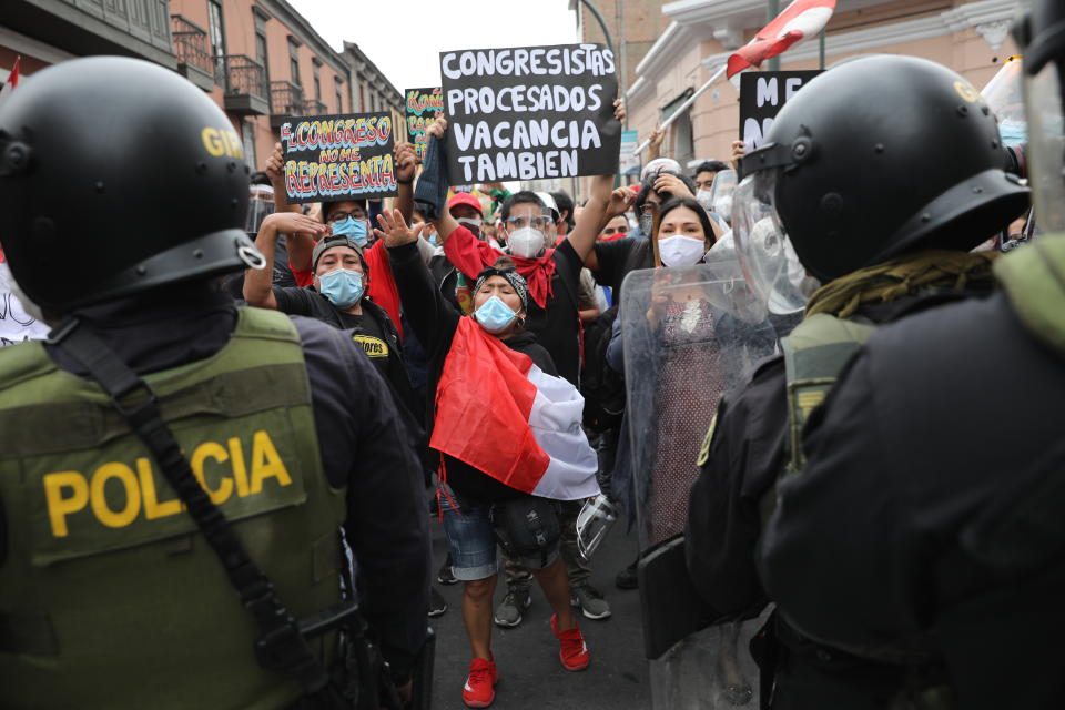 Police block supporters of former President Martin Vizcarra from reaching Congress as lawmakers swear-in Manuel Merino, head of Peru's legislature, as the new president in Lima, Peru, Tuesday, Nov. 10, 2020. Congress voted to oust Vizcarra over his handling of the new coronavirus pandemic and unproven allegations of corruption years ago. (AP Photo/Rodrigo Abd)