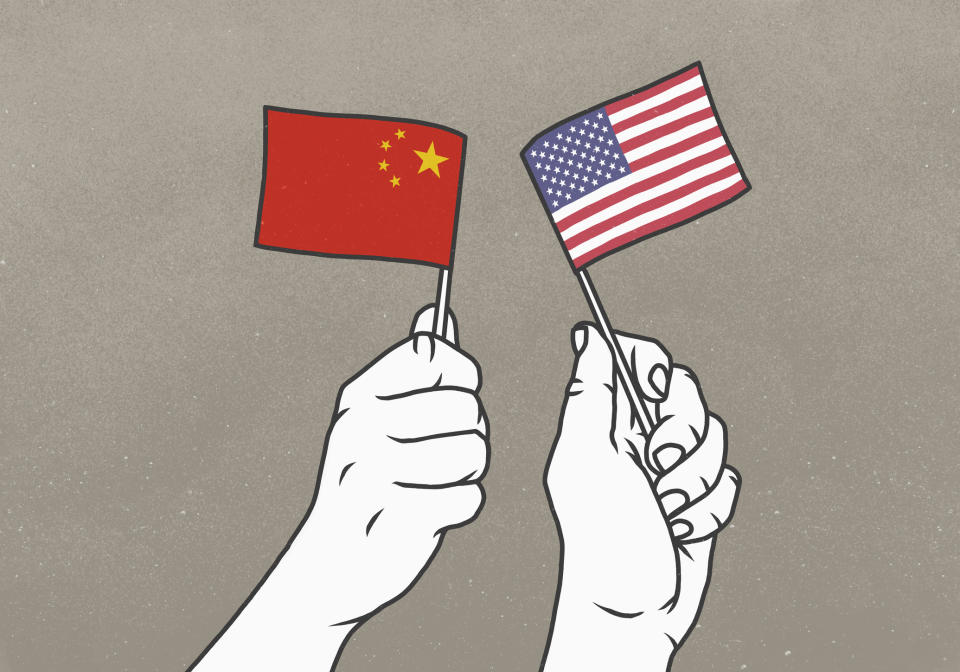 Hands waving small American and Chinese flags