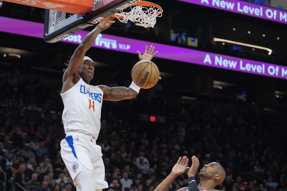 Los Angeles Clippers' Terance Mann dunks over Phoenix Suns' Chris Paul during the first half of an NBA basketball game Thursday, Feb. 16, 2023, in Phoenix. (AP Photo/Darryl Webb)