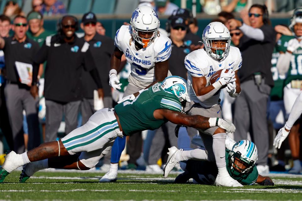 Memphis running back Sutton Smith (15) is tackled by Tulane linebacker Nick Anderson (1) during the second half of an NCAA college football game in New Orleans, Saturday, Oct. 22, 2022. Tulane won 38-28. (AP Photo/Tyler Kaufman)