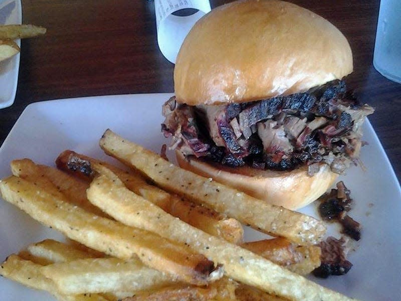 brisket sandwich on a bun with fries