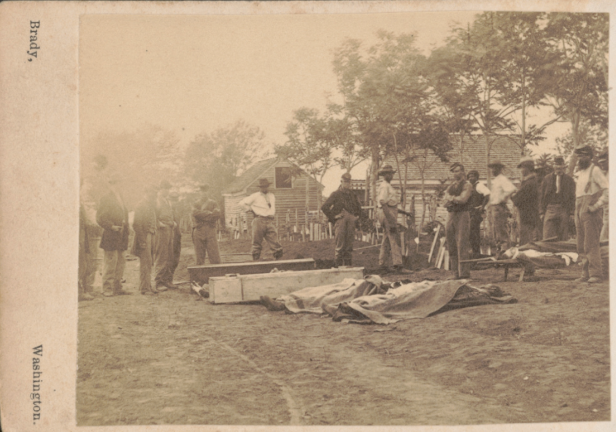 <span class="caption">Soldiers and African American workers standing near caskets and dead bodies covered with cloths during Grant's Overland Campaign. </span> <span class="attribution"><a class="link " href="https://www.loc.gov/item/2019633431/" rel="nofollow noopener" target="_blank" data-ylk="slk:Matthew Brady/Library of Congress Prints and Photographs Division;elm:context_link;itc:0;sec:content-canvas">Matthew Brady/Library of Congress Prints and Photographs Division</a></span>