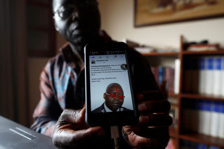 Simon Munzu, a former UN official, who is campaigning for peace in the Anglophone regions of Cameroon, shows a threat message posted against him on social media by separatists during an interview with Reuters in Yaounde, Cameroon October 3, 2018. Picture taken October 3, 2018. REUTERS/Zohra Bensemra