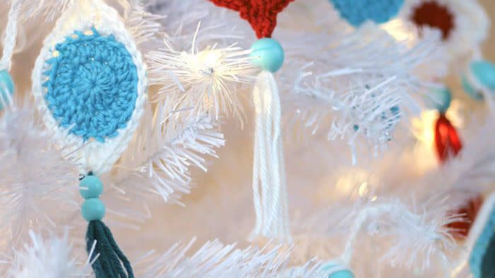 retro styled crochet ornaments in blue and white or red and white, with blue beads and tassels hanging down from them