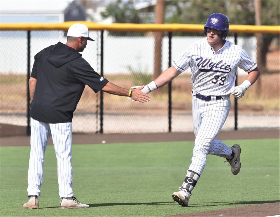 Wylie's Garrett Graham, right, is congratulated by coach Grant Martin after hitting a solo homer in the fifth inning of Game 2 against Plainview. The blast gave Wylie a 10-2 lead. Wylie won the game 11-7 to sweep the best-of-three Region I-5A bi-district playoff series 2-0 on May 6 in Lamesa.