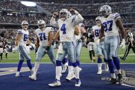 Dallas Cowboys' Sean McKeon (84), La'el Collins (71) and Osa Odighizuwa (97) look on as quarterback Dak Prescott (4) celebrates scoring a touchdown on a running play in the second half of an NFL football game against the Atlanta Falcons in Arlington, Texas, Sunday, Nov. 14, 2021. (AP Photo/Michael Ainsworth)