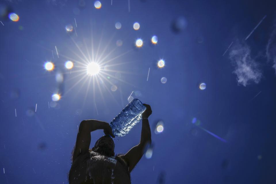 FILE - A man pours cold water onto his head to cool off on a sweltering hot day in the Mediterranean Sea in Beirut, Lebanon, July 16, 2023. The last 12 months were the hottest Earth has ever recorded, according to a new report Thursday, Nov. 9, by Climate Central, a nonprofit science research group. (AP Photo/Hassan Ammar, File)