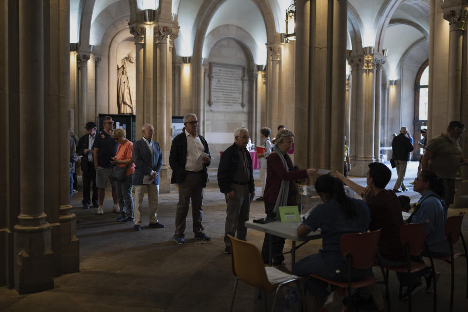 People wait in line to cast their ballots during local elections in Barcelona, Spain, Sunday, May 28, 2023. Spain goes to the polls on Sunday for local and regional elections seen as a bellwether for a national vote in December, with the conservative Popular Party (PP) steadily gaining ground on the ruling Socialists in key regions. (AP Photo/Emilio Morenatti)