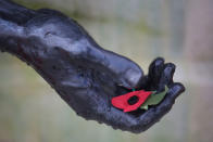 <p>A poppy rests in the hand of a statue during the annual Armistice Day Service at The National Memorial Arboretum on Nov. 11, 2017 in Alrewas, England. (Photo: Christopher Furlong/Getty Images) </p>