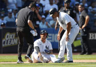 New York Yankees second baseman Gleyber Torres, bottom, reacts after an ankle injury during the ninth inning of a baseball game against the Houston Astros, Sunday, June 26, 2022, in New York. At right is New York Yankees third base coach Luis Rojas. (AP Photo/Noah K. Murray)