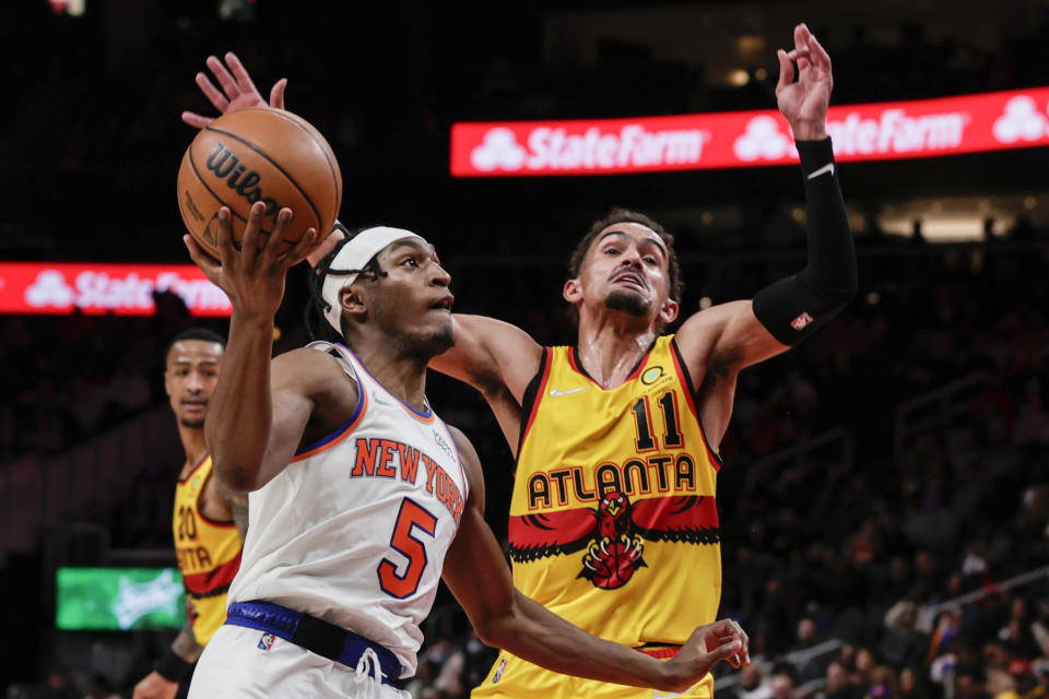New York Knicks guard Immanuel Quickley (5) goes up for a lay up around Atlanta Hawks guard Trae Young (11) during the second half of an NBA basketball game Saturday, Jan. 15, 2022, in Atlanta. (AP Photo/Butch Dill)