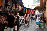 People walk past shops in the Medina, in the Old City of Tunis