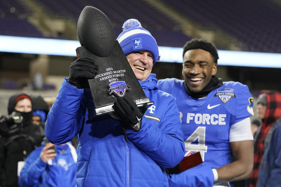 Air Force coach Troy Calhoun, left, lifts the trophy next to quarterback Haaziq Daniels (4) after the team's 30-15 win over Baylor in the Armed Forces Bowl NCAA college football game in Fort Worth, Texas, Thursday, Dec. 22, 2022. (AP Photo/LM Otero)