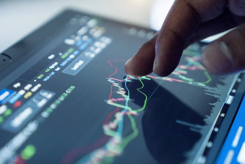 Market Analyze with Digital Monitor focus on tip of finger.