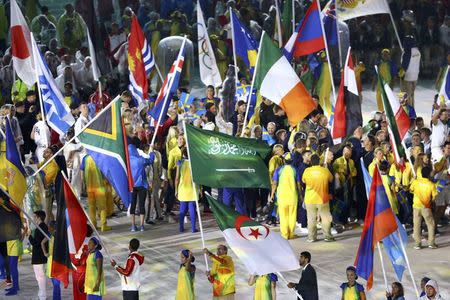 2016 Rio Olympics - Closing Ceremony - Maracana - Rio de Janeiro, Brazil - 21/08/2016. A volunteer holds the flag of Saudi Arabia as other flagbearers lead their countries' contingents on the stage. REUTERS/Leonhard Foeger