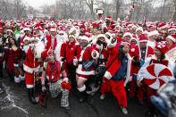 Revellers dressed as Santa Claus pose for a picture at a park during the SantaCon event in New York December 14, 2013. Every year since 1997, thousands of men and women have dressed up as Santas, elves, reindeer or some other holiday confection and descended on the city's streets for a daylong bar crawl that begins with good cheer and, for many, inevitably ends in a blurry booze-soaked haze. Many come from Long Island and New Jersey, getting a head start on the festivities on the train ride into the city. REUTERS/Eduardo Munoz (UNITED STATES - Tags: SOCIETY ENTERTAINMENT TPX IMAGES OF THE DAY)