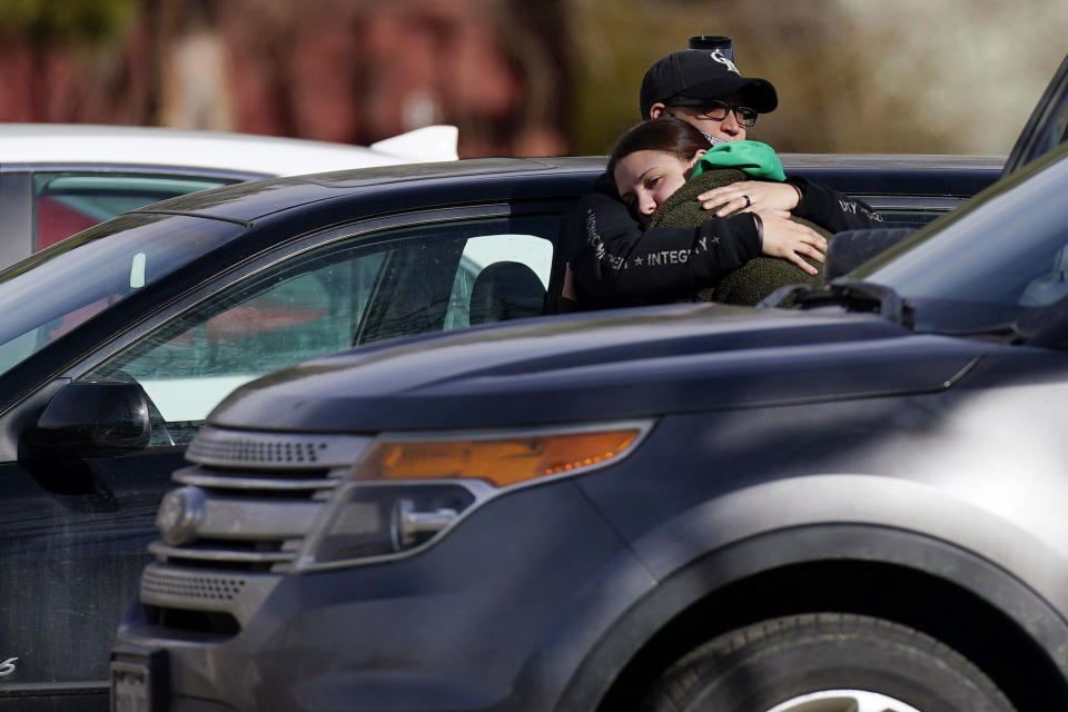 A couple embrace outside the Legacy Assisted Living at Lafayette care facility, Wednesday, Feb. 3, 2021, in Lafayette, Colo. A 95-year-old resident of the assisted care home was taken into police custody Wednesday after allegedly shooting an employee at the center. (AP Photo/David Zalubowski)